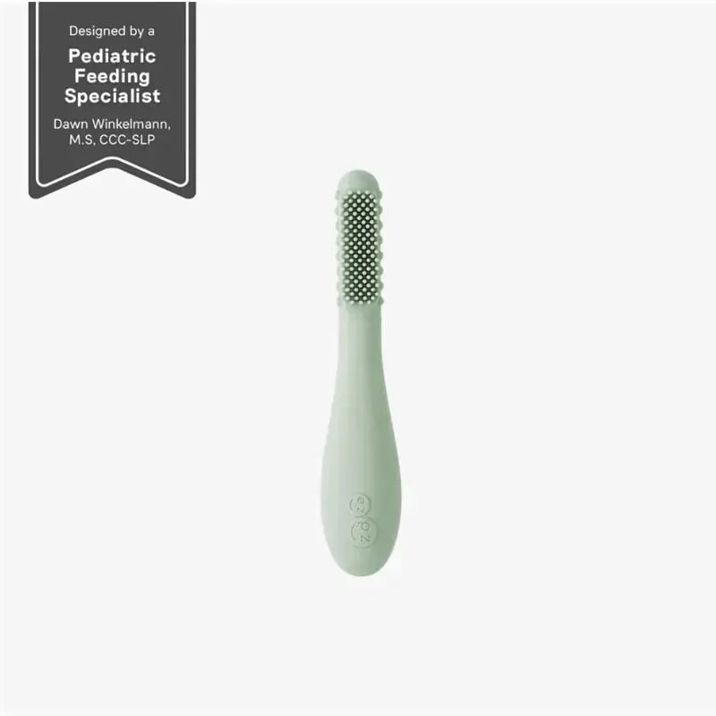 Sage-colored Ezpz Baby-Led™ Toothbrush with textured bristles, designed for infants to promote self-feeding and oral care.