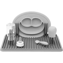Gray Ezpz drying rack featuring compartments for bottles, a spoon, and pacifiers, designed for efficient drying of baby items.