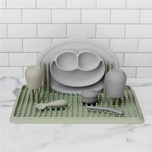 Ezpz Drying Rack in sage color, featuring silicone drying mats, plates, cups, and utensils for child feeding.