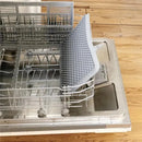 Ezpz Drying Rack in sage color positioned inside a dishwasher, designed for air-drying dishes efficiently.