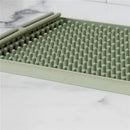 Ezpz drying rack in sage color, featuring a textured surface with raised pegs for efficient drying.