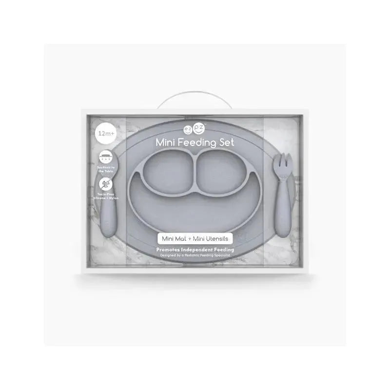 Ezpz Mini Feeding Set in Pewter, includes a mat with two compartments and mini utensils, promoting independent feeding for children 12 months and older.