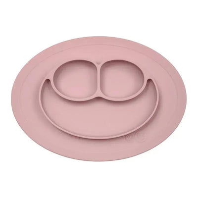 Ezpz Mini Mat in Blush, a silicone feeding mat with three compartments and a smiley face design, ideal for young children.