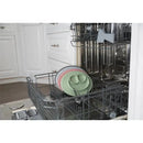 Ezpz Mini Mat in blush, placed in a dishwasher alongside additional silicone mats in various colors.