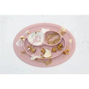 Ezpz Mini Mat in blush color with remnants of food, featuring two divided sections and a small oval shape.