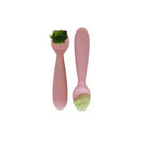 Two blush pink mini utensils designed for toddlers, featuring a spoon with broccoli and another with green food.