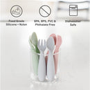 Ezpz Mini Utensils in sage, pink, and gray stacked in a clear glass cup; made of food-grade silicone and nylon, dishwasher safe.