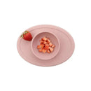 ezpz Tiny Bowl in blush color filled with diced strawberries, accompanied by a whole strawberry on the side.