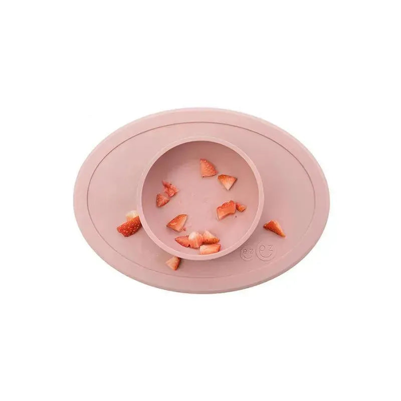ezpz Tiny Bowl in blush color, featuring a circular inner bowl with scattered strawberry pieces and a raised edge.