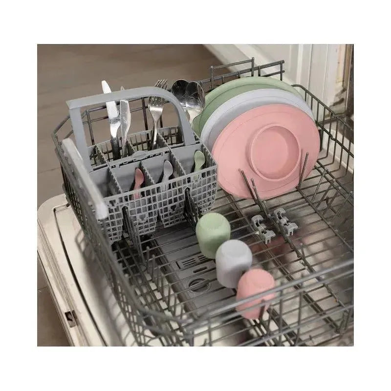 Ezpz Tiny Bowl in sage, along with various utensils and plates, arranged in a dishwasher.