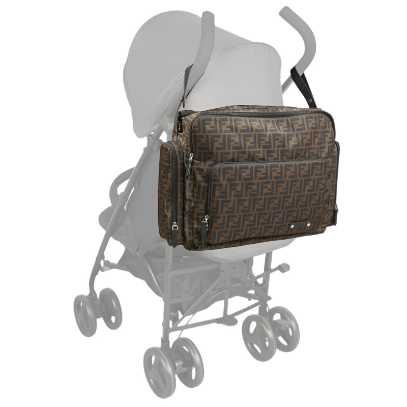 Brown Fendi Baby FF Logo Changing Bag attached to a stroller, featuring zippered compartments and the iconic FF pattern.