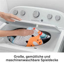 3-in-1 Music, Glow and Grow Gym Play Mat being placed in a washing machine, showcasing its machine-washable feature.