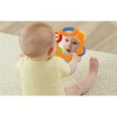 A baby in a yellow onesie smiles at its reflection in a colorful, textured baby mirror.