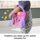 Colorful Fisher Price Laugh & Learn Purse held by a toddler, featuring lights, a music button, and playful design elements.