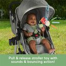 Fisher Price Baby Stroller Toy Planet Friends Sea Me Bounce Turtle plush toy engaging a smiling baby in a stroller, with vibrant colors and bouncing action.