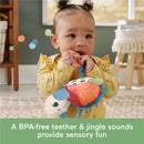 Baby holding a colorful plush turtle teether with jingle sounds, promoting sensory play.