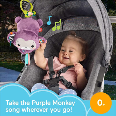 Baby seated in a stroller holds a purple plush monkey toy with a smiling face, featuring colorful tags and music notes.