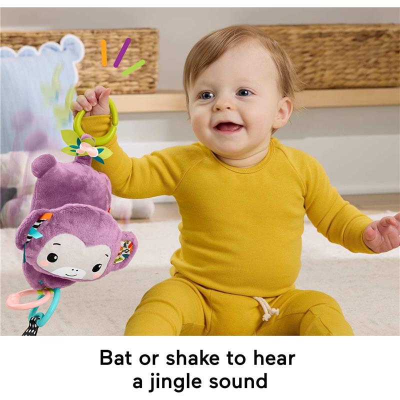 Baby playing with the Fisher Price Purple Monkey plush toy, which jingle sounds when shaken or batted.