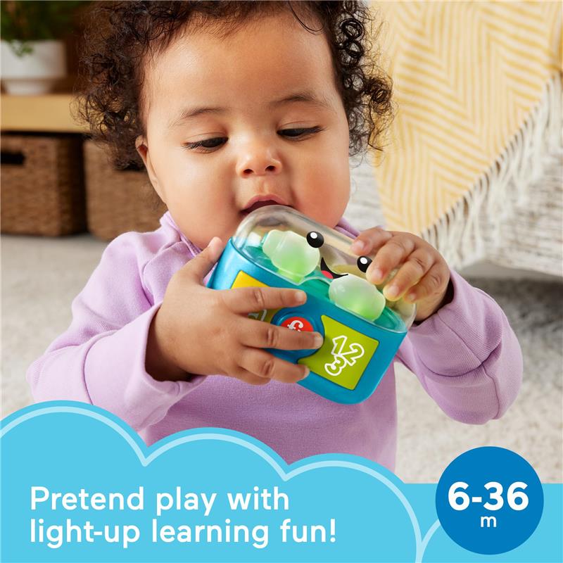 Baby holding blue Fisher Price toy with smiling face, buttons, and light-up features, promoting pretend play and learning.