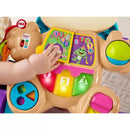 A baby’s hand interacts with the Fisher Price Laugh & Learn Smart Stages Sis Walker, featuring colorful buttons, educational music, and lights.
