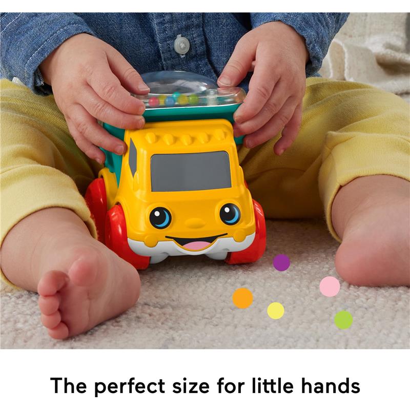 Colorful Fisher Price Poppity Pop Dump Truck toy held by a child, featuring a smiling face and colorful balls surrounding it.