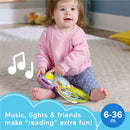 Baby sitting on the floor with a purple monkey musical storybook toy, engaging with light and sound features, smiling.