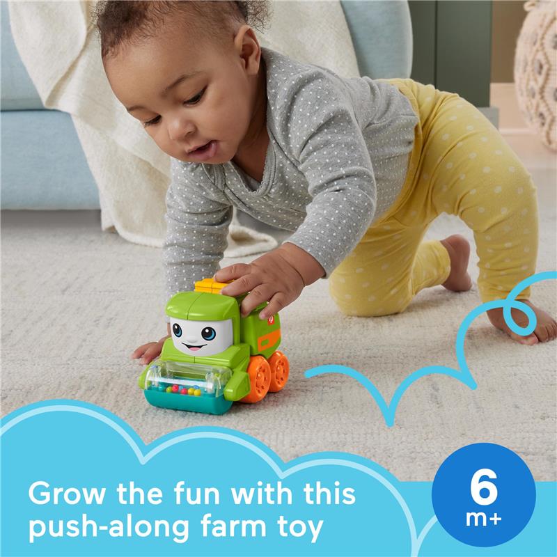Fisher Price Baby Toy Rollin’ Tractor, a push-along vehicle with fine motor activities, being played with by a baby.