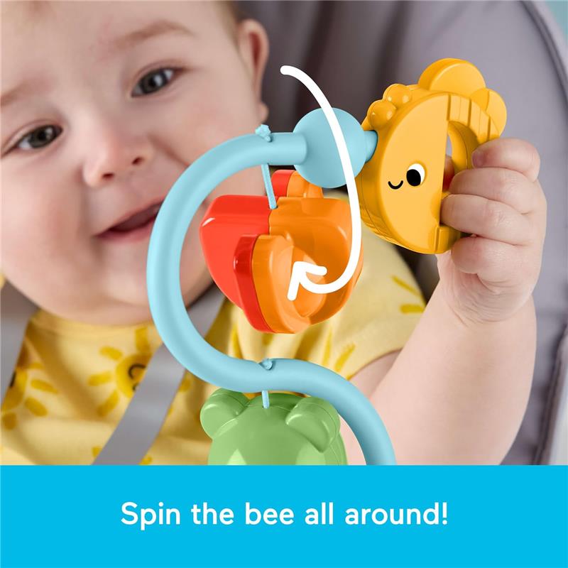 Baby playing with a colorful spinning toy attached to a high chair, featuring a bee and fruits, encouraging sensory exploration.
