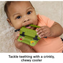 Infant bites a green, crinkly cooler toy with sports stickers, promoting teething relief and sensory play.