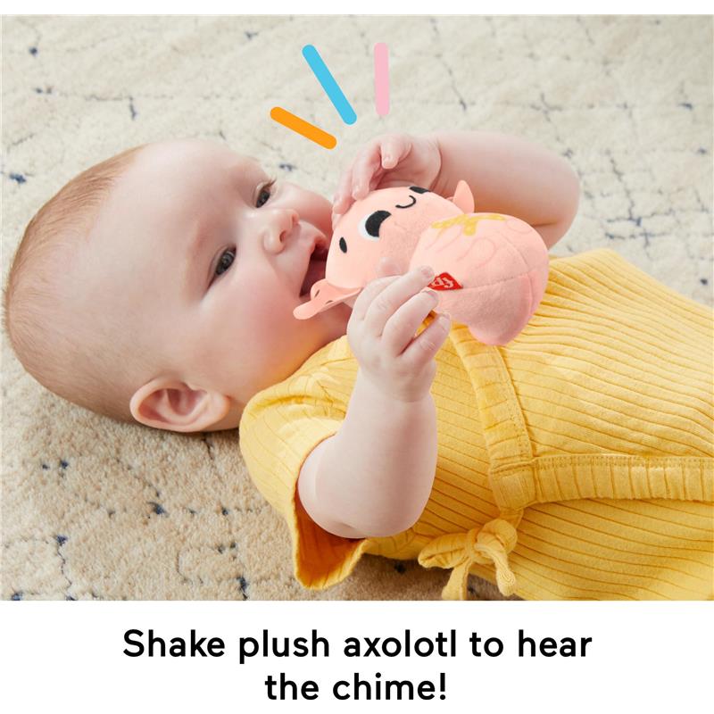 Baby in a yellow outfit shakes a plush axolotl toy that creates a chime sound.