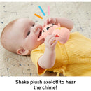 Baby in a yellow outfit shakes a plush axolotl toy that creates a chime sound.