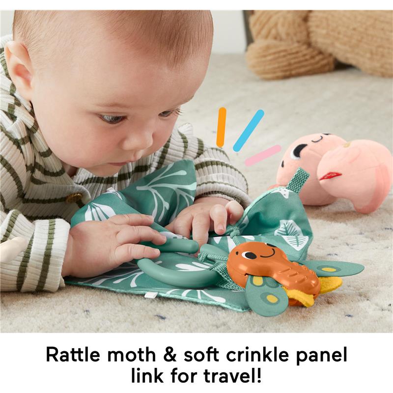 Baby exploring the Fisher Price So Many Senses Set, featuring a rattling moth and crinkle panel, on a soft surface.