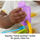 Purple squishy bottle designed as a toy, held by an infant hand, with colorful keys and a learning element visible.