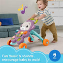 Fisher-Price Baby Walker Learn with Me Purple Monkey toy, encouraging walking with music and lights, used by a smiling toddler.