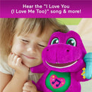 Toddler girl smiling while holding a purple Barney plush toy with a musical feature and a microphone accessory.