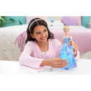 A child smiles while holding a Fisher Price Disney Princess Light Up Cinderella doll, featuring a blue dress and a magic wand.