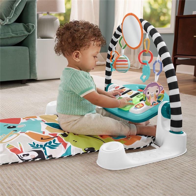 Infant playing with the Fisher Price Glow & Grow Kick & Play Gym, featuring colorful toys and a musical activity center.