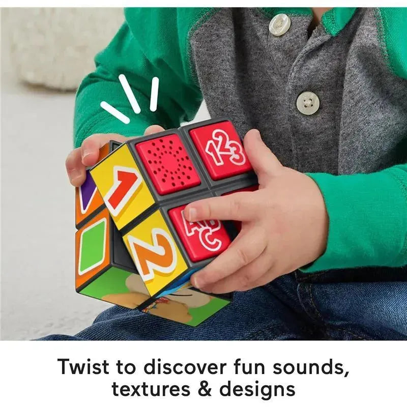Fisher Price Laugh & Learn Puppy Activity Cube held by a child, featuring colorful buttons and textures for sound and discovery.
