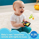 A happy baby holds a Fisher-Price Laugh & Learn Stream & Learn Remote, featuring colorful buttons, lights, and music notes.