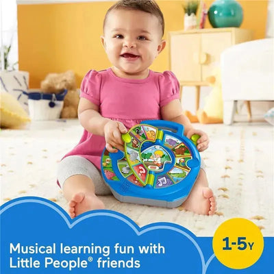 Baby seated on a carpet, smiling and holding a Fisher Price Little People Animal See N Say toy, featuring animal images and musical notes.