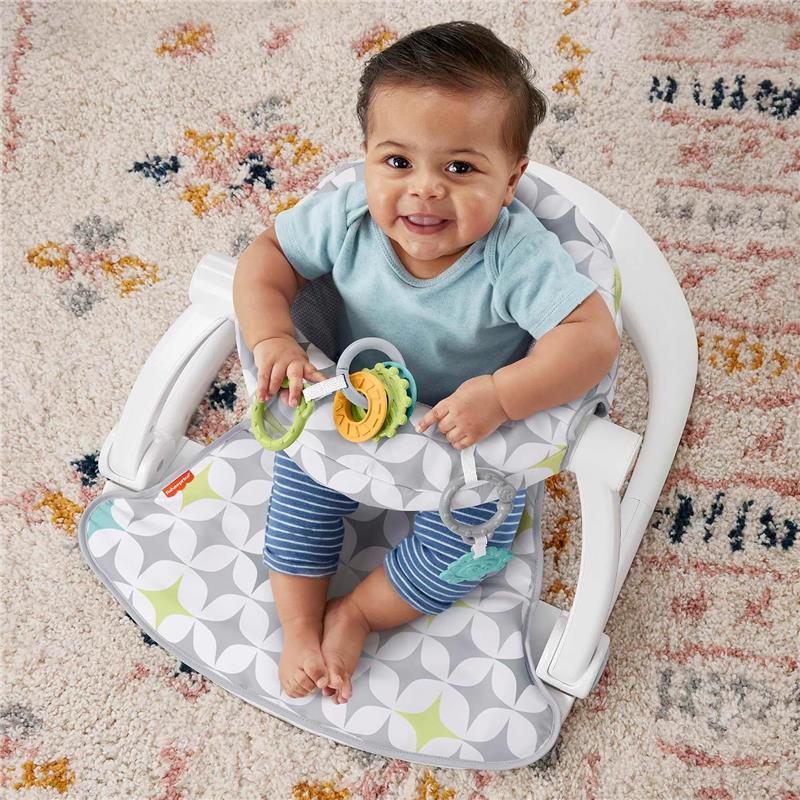 Portable baby chair with developmental toys; a smiling baby sits in a gray and white patterned seat, holding colorful rings.