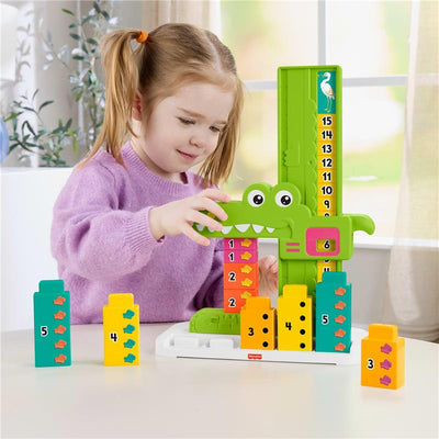 Child stacking colorful blocks on a green alligator counting toy, learning numbers and counting from 1 to 15.