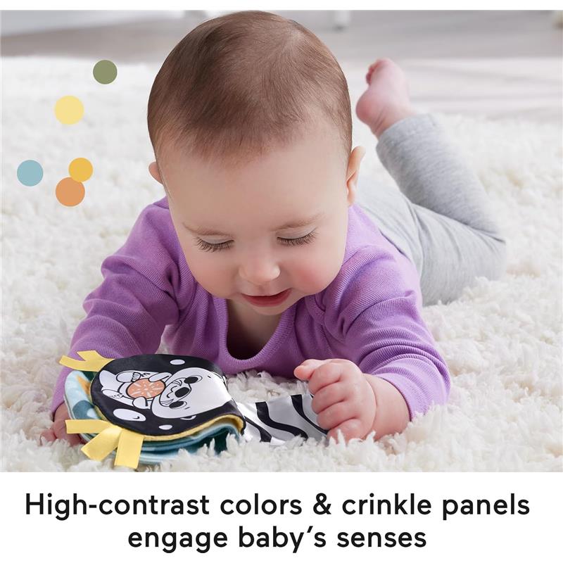 Infant playing on a soft surface, focused on a colorful sensory toy with crinkle panels and high-contrast colors.