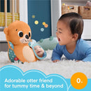 Plush otter toy with a mirror, designed for tummy time, engages a smiling baby on soft white rug.