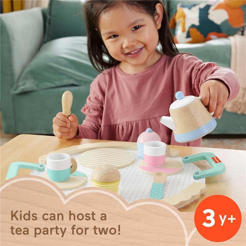 Wooden pretend play tea set by Fisher Price, featuring a smiling child holding a teapot and various tea accessories.