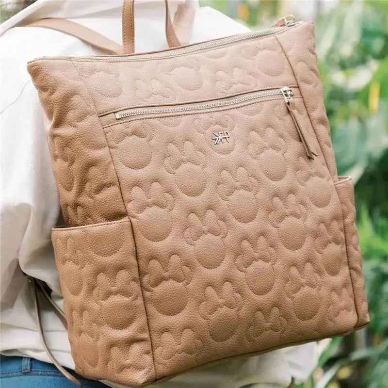 Minnie Mouse minimal backpack in a tan color with embossed Mickey Mouse designs, featuring a front zipper and side pockets.