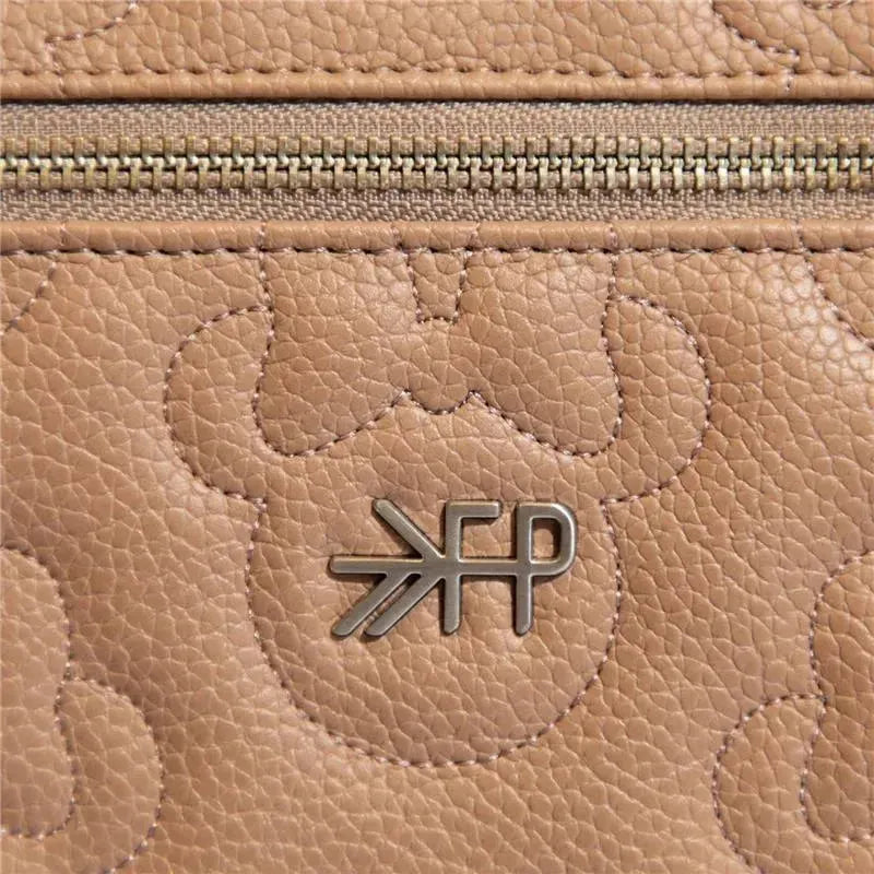 Minnie Mouse minimal backpack featuring a textured, tan leather surface and a metal logo detail.