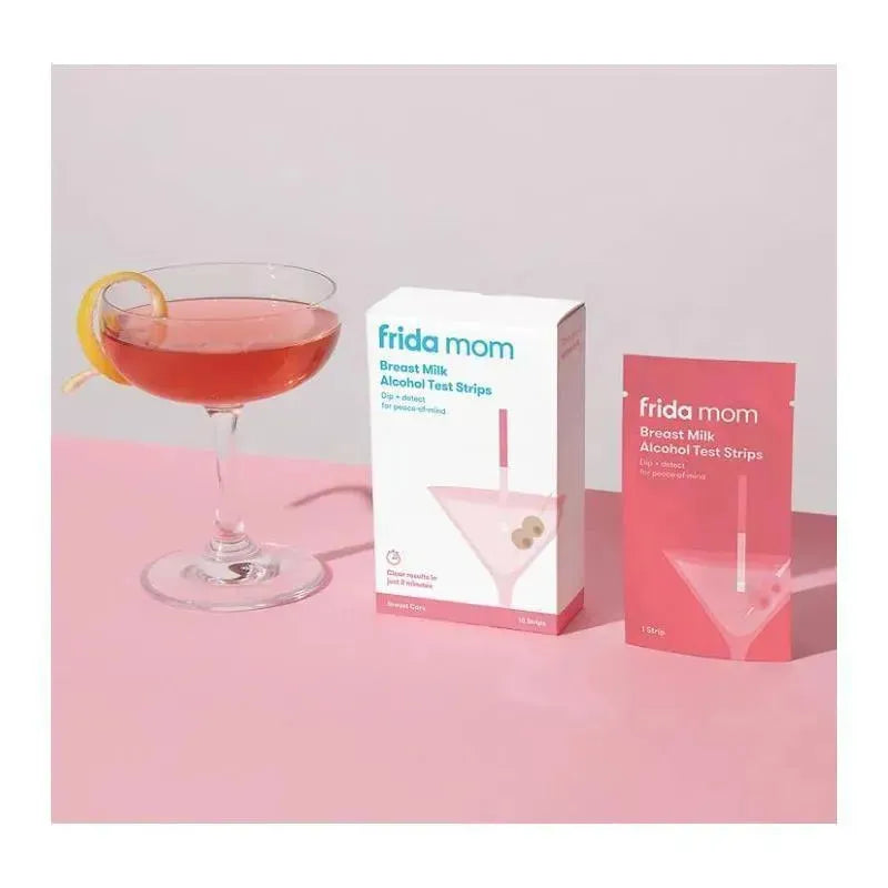 Frida Mom Breast Milk Alcohol Detection Test Strips packaging beside a cocktail glass with a pink drink and lemon twist.