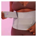 Postpartum abdominal support binder by Frida Mom being worn, highlighting its adjustable hook-and-loop closures and light gray color.