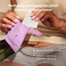 Frida Mom Uterine Recovery Heat Relief Patches in a hand, designed for easy, cord-free heat relief after childbirth.
